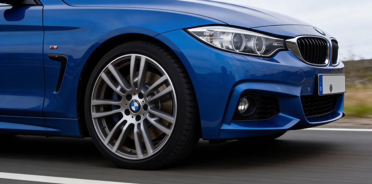 BMW M4 Gran Coupe parked in a modern urban setting, showcasing its sleek design and sporty features.