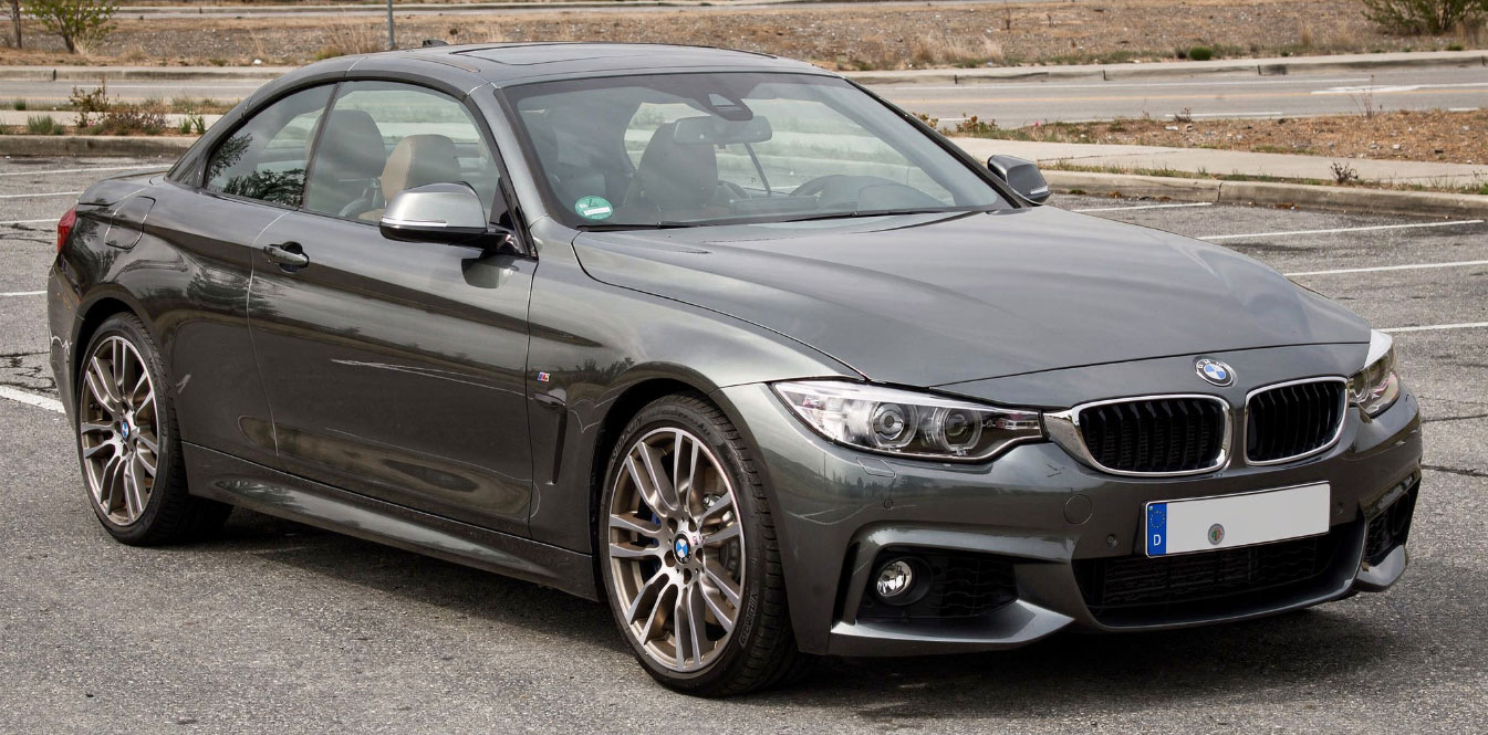 BMW M4 Coupe review showcasing its sleek design and performance features on a scenic road.