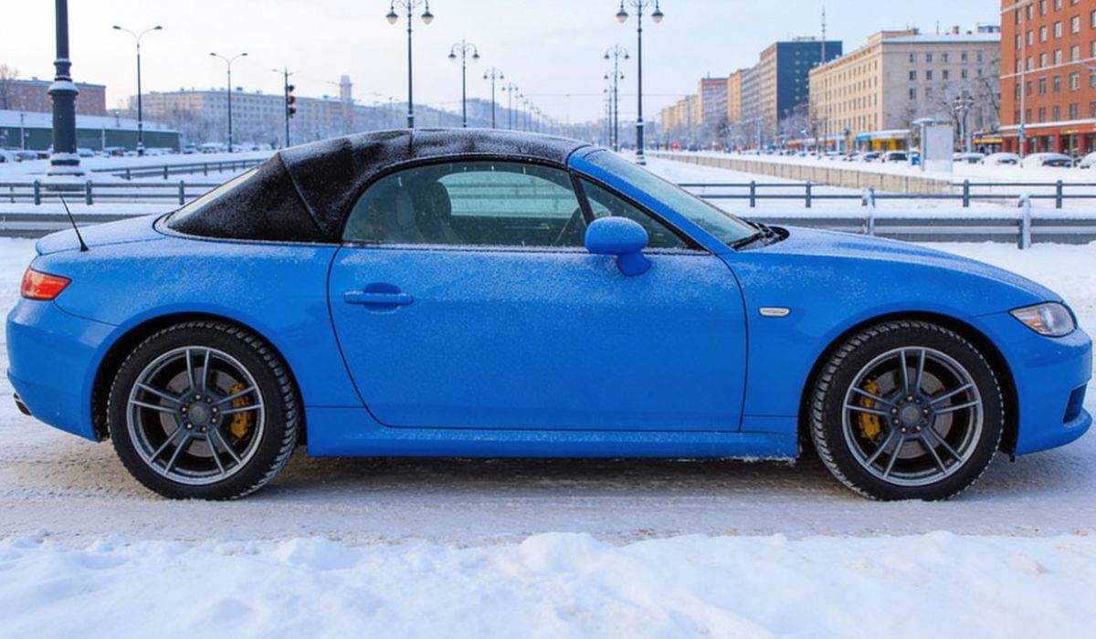 A blue sports car parked on a snowy street, surrounded by white snow and a clear blue sky.