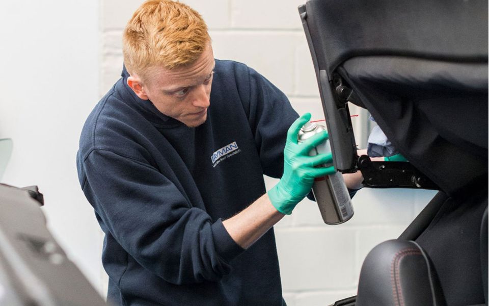 mechanic cleans soft top roof