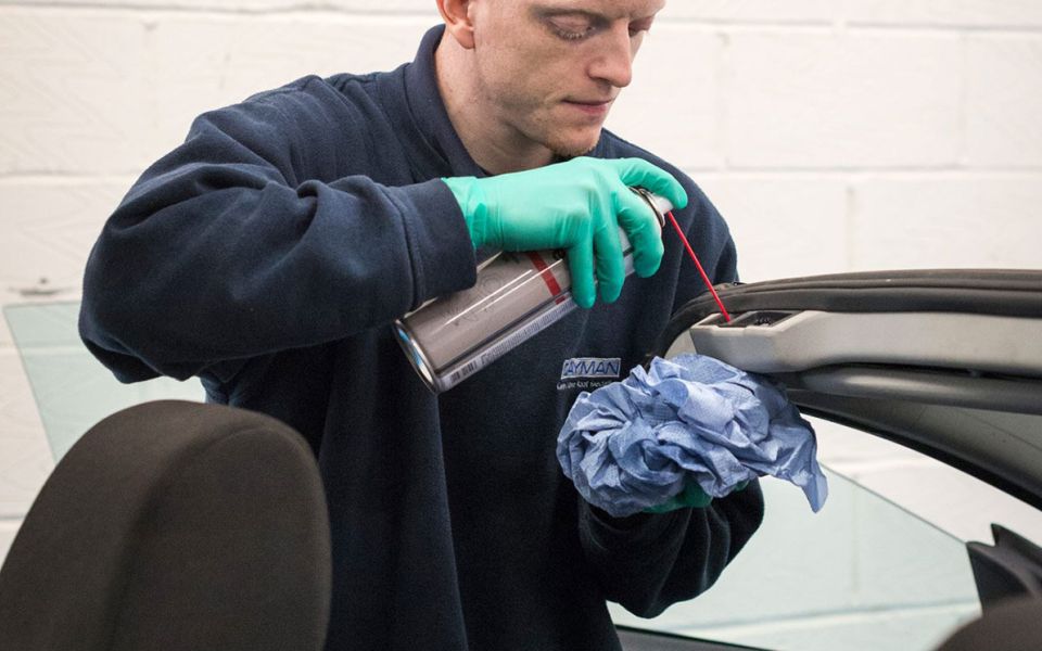 mechanic cleans soft top roof