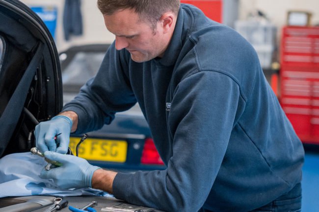 mechanic works on car