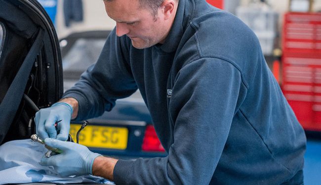 mechanic works on car